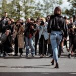 woman walking taking photo by people