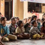 group of childrens sitting on ground