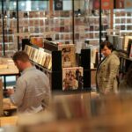 A couple of people standing in a room filled with books